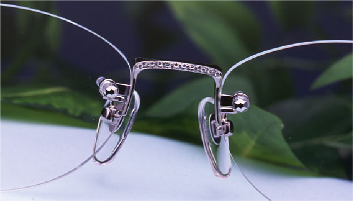 無框珠寶眼鏡的鼻橋處特寫，展示上方鑲嵌鑽石的貴金屬白金鼻橋